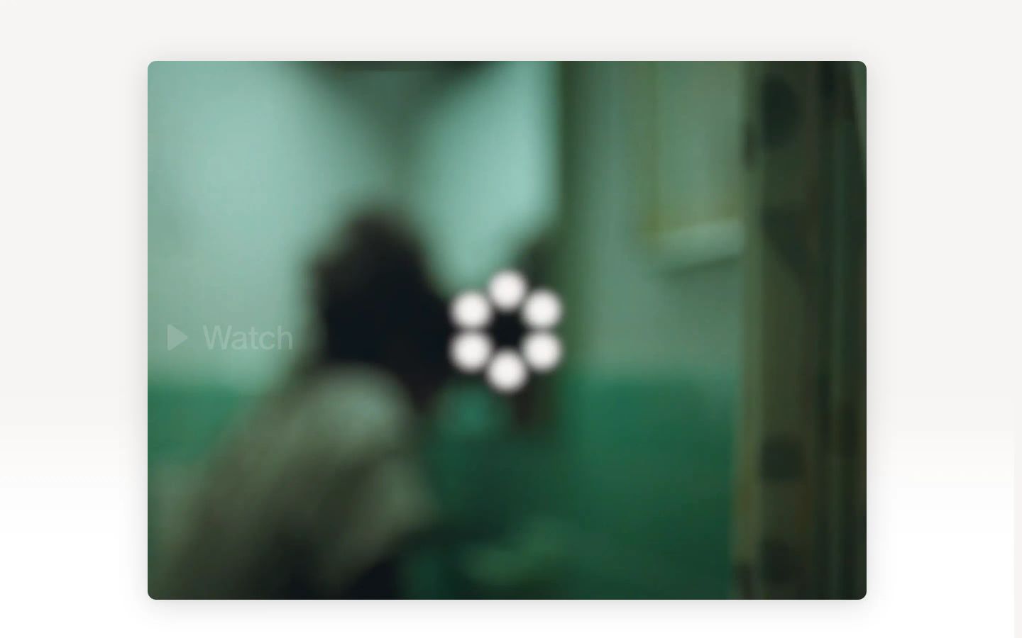 A blurred cinematic video embed floats centrally on a muted warm canvas, evoking quiet suspense and curiosity.
