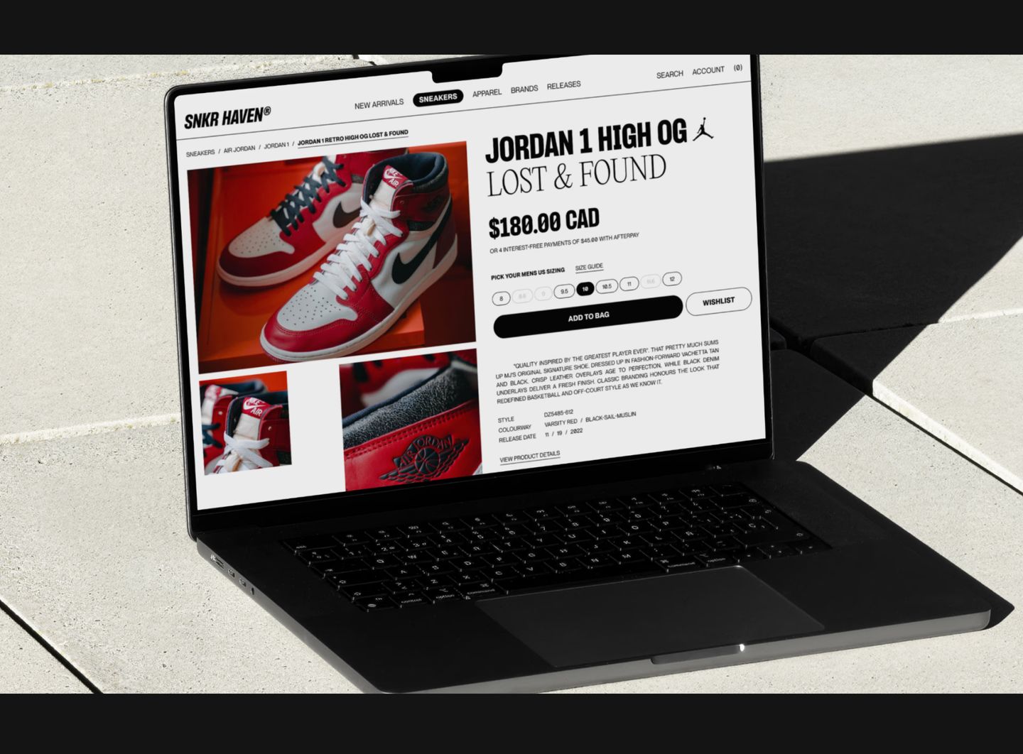 A crisp digital e-commerce mockup rendered on a laptop resting on sunlit architectural stone.