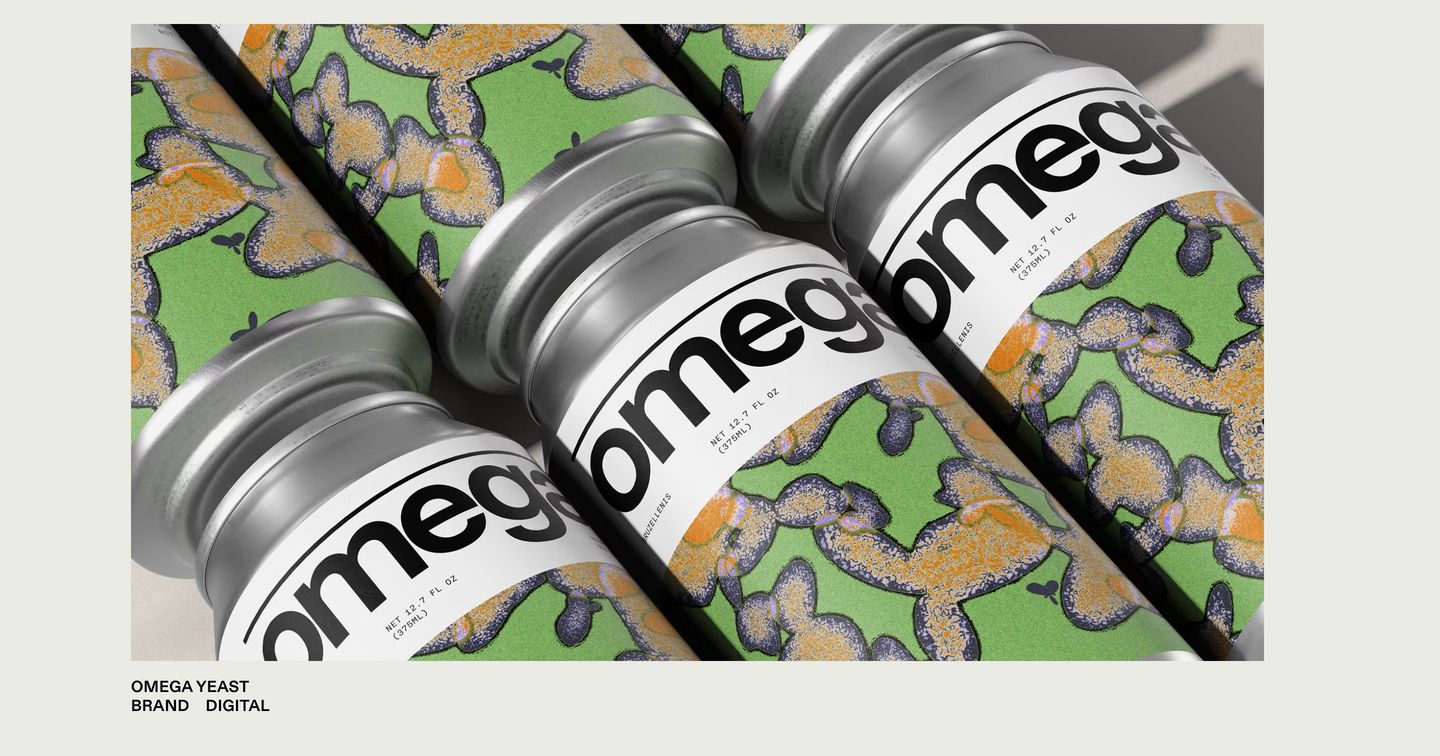 Tactile and graphic, displaying bespoke beverage can packaging with bold typography against a pale neutral gallery frame.
