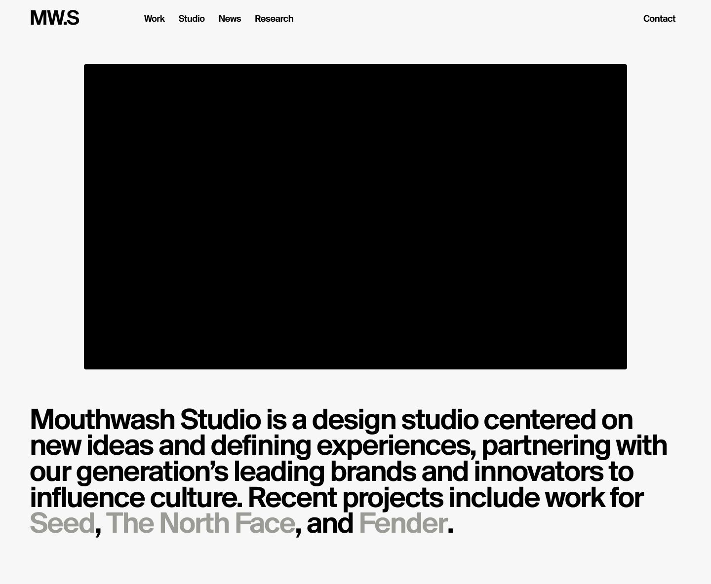 Quiet, disciplined Swiss minimalism with bold typography anchored by an oversized central media block.
