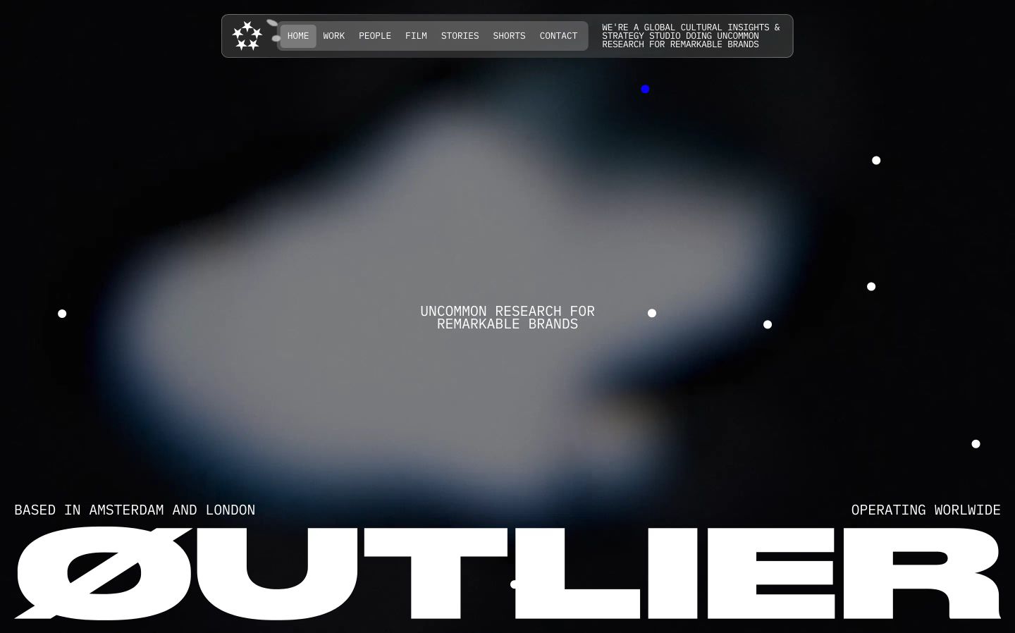 Dark, atmospheric hero with an ethereal glowing cloud backdrop, constellation-like pinpoints, and giant monolithic typography anchored at the base.